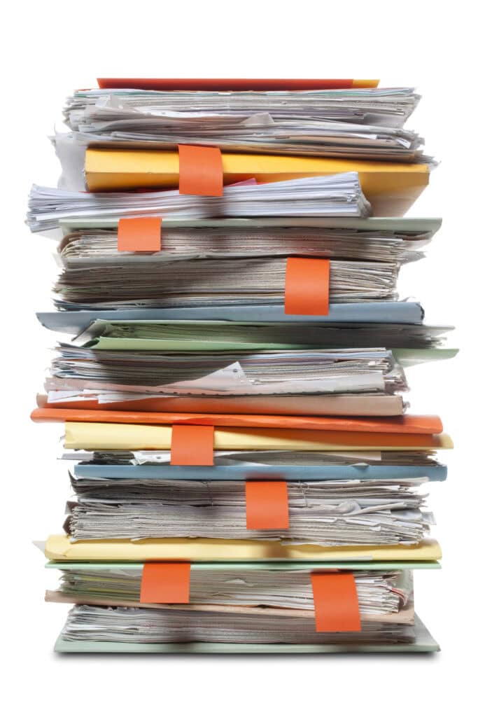 Aktenstapel mit Dokumenten bei Kanzlei Selinger, symbolisiert Büroarbeit und Organisation.